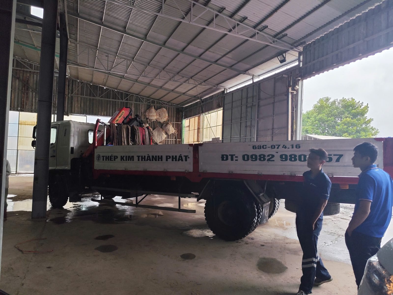 Xe tải Hino gắn cẩu PALFINGER PK11002 bốc dỡ hàng tại kho vật liệu xây dựng ở Miền Tây